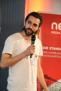 Tarek Müller hat an diesem Abend nicht nur die Rolle des Jurors inne, sondern führt das Publikum im betahaus durch den spannenden Abend.