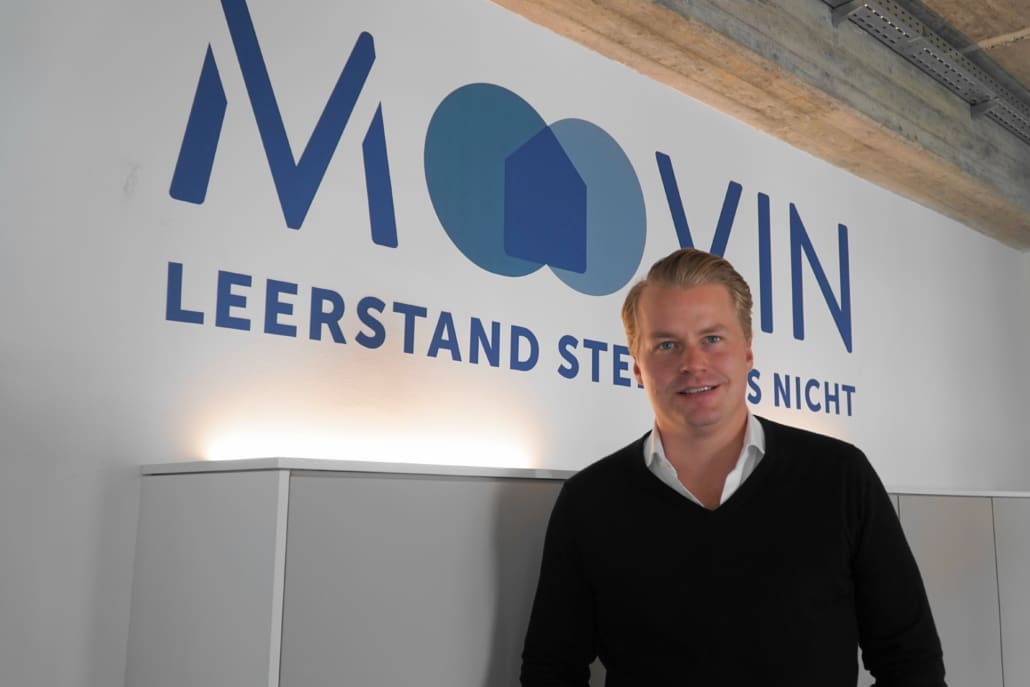 Geschäftsführer Fabian Mellin vor dem moovin-Logo im Büro in der Hamburger Sternstraße.