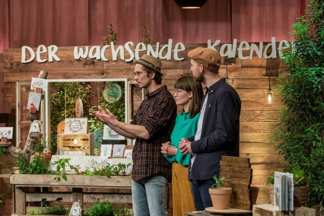 Orlando Zaddach Manuela Baron und Tobias Aufenanger von primoza bringen einen Jahreskalender mit Samenblättern in die Höhle. (Foto: TVNOW / Bernd-Michael Maurer)