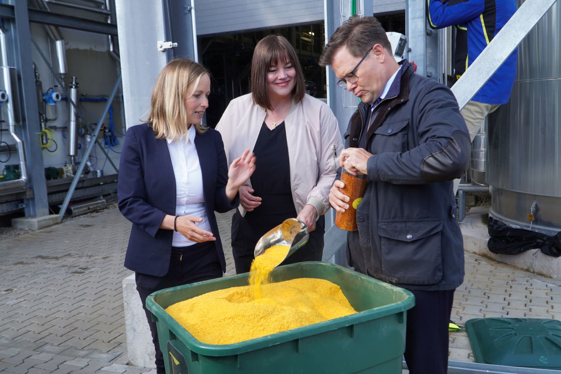 traceless-Gründerin Dr. Anne Lamp erklärt Hamburgs Zweiter Bürgermeisterin Katharina Fegebank und Bundesumweltminister Carsten Schneider, wie das Granulat produziert wird.