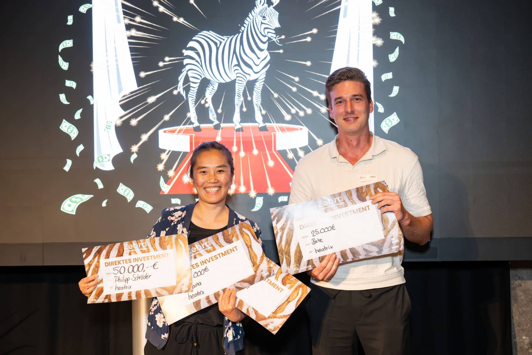 Dr. Wei Wu und Dr. Stefan Gasow von Heatrix mit ihrer Kollektion von symbolischen Siegerschecks.